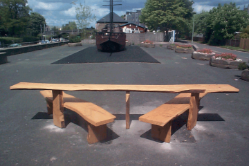 Wooden easy access Picnic Table Bench in front of boat by river