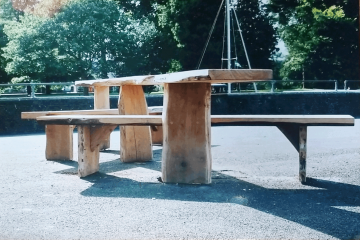 All Ability wooden Picnic table with bench installed on tarmac by a river