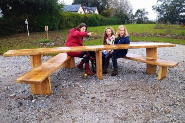 young family sitting on a wooden bench in a park